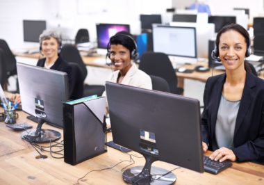 Cropped shot of three female call center representatives wearing headsets